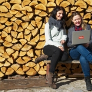 zwei-Frauen-mit-Laptop-Holzstoss